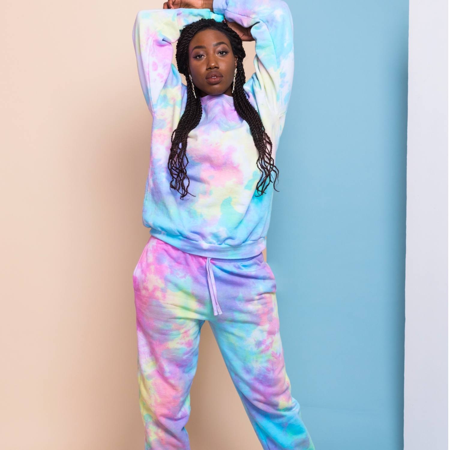 http://mashaapparel.com/cdn/shop/files/Woman-stretching-arms-in-pastel-tie-dye-sweatsuit-against-blue-and-peach-background.jpg?v=1706039115
